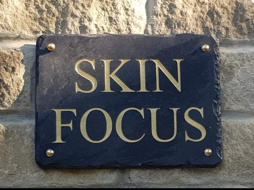 Skin Focus's gold-lettered slate sign outside the salon